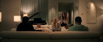 Movie still from “Keanu” (2016), directed by Peter Atencio – A group of people sitting on top of couches in a living room; Wide shot, High angle