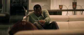A man sitting on top of a white couch in a room