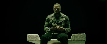 Movie still from “Keanu” (2016), directed by Peter Atencio – A man holding a cat while sitting on a bench; Medium shot, Overhead angle