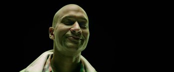 Movie still from “Keanu” (2016), directed by Peter Atencio – A man with a shaved head smiling for the camera; Extreme Close Up shot, Low angle