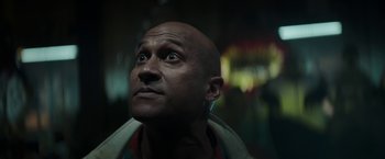 Movie still from “Keanu” (2016), directed by Peter Atencio – A bald man looking up into the air; Close Up shot, Low angle