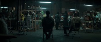 Movie still from “Keanu” (2016), directed by Peter Atencio – A man sitting on a chair in a room; Wide shot, High angle