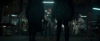 Movie still from “Keanu” (2016), directed by Peter Atencio – A group of people standing around in a dark room; Wide shot, Over the shoulder angle