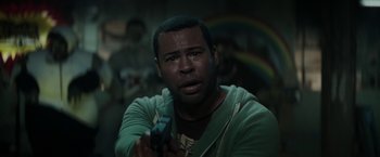 Movie still from “Keanu” (2016), directed by Peter Atencio – A man holding a gun while wearing a green hoodie; Close Up shot, Over the shoulder angle