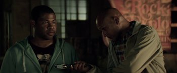 Movie still from “Keanu” (2016), directed by Peter Atencio – Two men are looking at a cell phone in a dark room; Close Up shot, Over the shoulder angle
