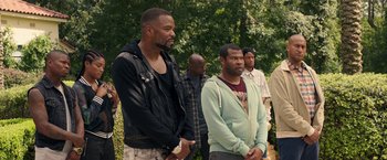 Movie still from “Keanu” (2016), directed by Peter Atencio – A group of men standing next to each other in front of trees; Medium shot, Over the shoulder angle