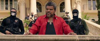 Movie still from “Keanu” (2016), directed by Peter Atencio – A man in a red shirt is standing in front of some people; Medium shot, Over the shoulder angle