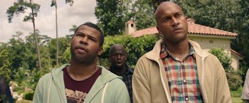 Movie still from “Keanu” (2016), directed by Peter Atencio – A group of men standing next to each other in front of a building; Close Up shot, Over the shoulder angle