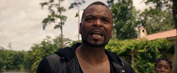 Movie still from “Keanu” (2016), directed by Peter Atencio – A person wearing a leather jacket with trees in the background; Close Up shot, Low angle