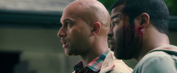Movie still from “Keanu” (2016), directed by Peter Atencio – A bald man and a black man looking at each other; Close Up shot, Over the shoulder angle