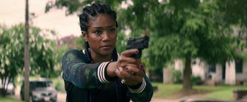 Movie still from “Keanu” (2016), directed by Peter Atencio – A woman holding a gun in her hand; Close Up shot, Over the shoulder angle