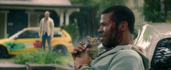 Movie still from “Keanu” (2016), directed by Peter Atencio – A man holding a kitten with blood on his face; Close Up shot, Over the shoulder angle