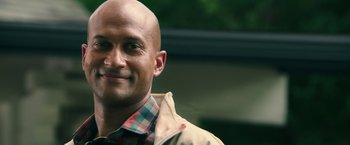 Movie still from “Keanu” (2016), directed by Peter Atencio – A man with a bald head smiling for the camera; Close Up shot, Over the shoulder angle