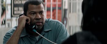 Movie still from “Keanu” (2016), directed by Peter Atencio – A man is sitting in front of a cell phone; Close Up shot, Over the shoulder angle