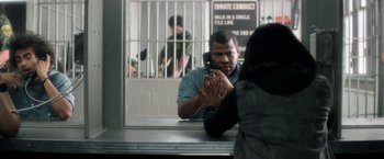 Movie still from “Keanu” (2016), directed by Peter Atencio – A man talking on a cell phone in front of a jail cell; Medium shot, Over the shoulder angle