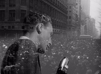 Movie still from “Keeper of the Flame” (1942), directed by George Cukor – A man in a crowd of people looking at a cell phone; Medium shot, High angle
