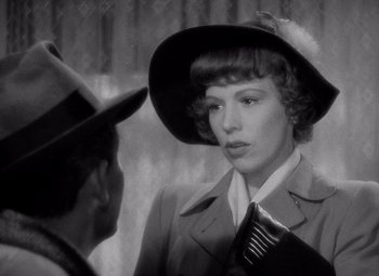 Movie still from “Keeper of the Flame” (1942), directed by George Cukor – An old photo of a woman wearing a hat and a coat; Close Up shot, Over the shoulder angle