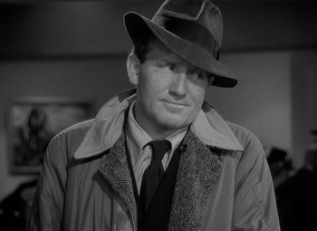 Movie still from “Keeper of the Flame” (1942), directed by George Cukor – A black and white photo of a man wearing a hat and a coat; Close Up shot, Over the shoulder angle