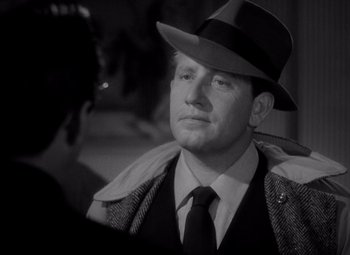 Movie still from “Keeper of the Flame” (1942), directed by George Cukor – A black and white photo of a man wearing a hat; Close Up shot, Low angle