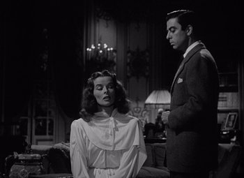 Movie still from “Keeper of the Flame” (1942), directed by George Cukor – A man and a woman standing next to each other in a room; Medium shot, Low angle