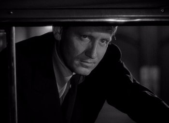 Movie still from “Keeper of the Flame” (1942), directed by George Cukor – A black and white photo of a man in a suit; Close Up shot, Low angle