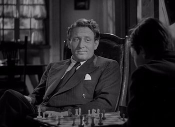 Movie still from “Keeper of the Flame” (1942), directed by George Cukor – A black and white photo of a man sitting in a chair; Close Up shot, High angle