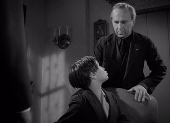 Movie still from “Keeper of the Flame” (1942), directed by George Cukor – An older man and a young boy in a room; Medium shot, Over the shoulder angle