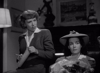Movie still from “Keeper of the Flame” (1942), directed by George Cukor – Two women sitting in front of each other in a room; Medium shot, Low angle