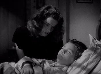 Movie still from “Keeper of the Flame” (1942), directed by George Cukor – An older woman is looking at a young boy in bed; Close Up shot, High angle