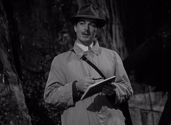 Movie still from “Keeper of the Flame” (1942), directed by George Cukor – A black and white photo of a man writing on a notepad; Medium shot, Low angle