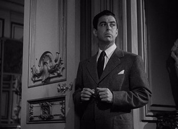 Movie still from “Keeper of the Flame” (1942), directed by George Cukor – A black and white photo of a man in a suit and tie; Medium shot, Low angle