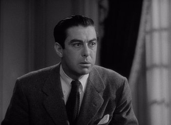 Movie still from “Keeper of the Flame” (1942), directed by George Cukor – Black and white photograph of a man wearing a suit and tie; Close Up shot, Low angle