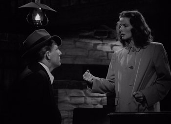Movie still from “Keeper of the Flame” (1942), directed by George Cukor – A man and a woman are talking to each other; Medium shot, Low angle