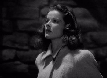 Movie still from “Keeper of the Flame” (1942), directed by George Cukor – A black - and - white photo of a woman in a coat; Close Up shot, Low angle