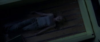 A woman laying on the ground in a dark room