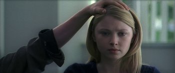 A woman getting her hair combed by a hairstylist