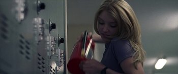 Movie still from “Keith” (2008), directed by Todd Kessler – A woman holding a red bag in her hands; Medium shot, Low angle