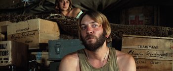 Movie still from “Kelly's Heroes” (1970), directed by Brian G. Hutton – A man with a beard and a woman in the background; Close Up shot, Low angle