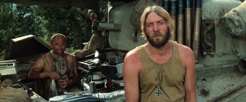 Movie still from “Kelly's Heroes” (1970), directed by Brian G. Hutton – A man with a beard and a cross on his shirt; Medium shot, Low angle