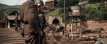 Movie still from “Kelly's Heroes” (1970), directed by Brian G. Hutton – A group of men standing next to each other on a dirt road; Wide shot, High angle