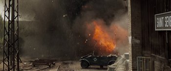 Movie still from “Kelly's Heroes” (1970), directed by Brian G. Hutton – An old car is burning in the middle of a field; Wide shot, Low angle