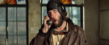 Movie still from “Kelly's Heroes” (1970), directed by Brian G. Hutton – A man wearing a leather jacket talking on a phone; Close Up shot, Low angle