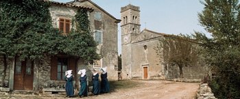 Movie still from “Kelly's Heroes” (1970), directed by Brian G. Hutton – A group of nuns walking in front of an old church; Extreme Wide shot, Low angle