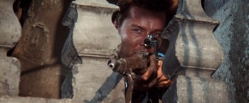Movie still from “Kelly's Heroes” (1970), directed by Brian G. Hutton – A man is holding a rifle and aiming it; Close Up shot, Low angle
