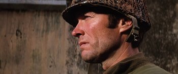 Movie still from “Kelly's Heroes” (1970), directed by Brian G. Hutton – A person wearing a hat; Close Up shot, Over the shoulder angle