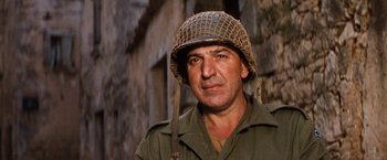Movie still from “Kelly's Heroes” (1970), directed by Brian G. Hutton – A man wearing a military uniform and a helmet; Close Up shot, Low angle