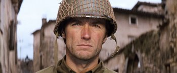 Movie still from “Kelly's Heroes” (1970), directed by Brian G. Hutton – A man wearing a military helmet and a uniform; Close Up shot, Over the shoulder angle