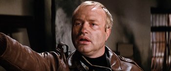 Movie still from “Kelly's Heroes” (1970), directed by Brian G. Hutton – An older man wearing a brown leather jacket; Close Up shot, Low angle