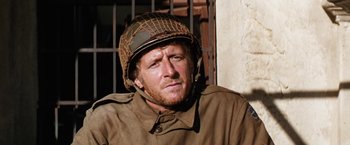 Movie still from “Kelly's Heroes” (1970), directed by Brian G. Hutton – A man wearing a military helmet and a uniform; Close Up shot, Over the shoulder angle