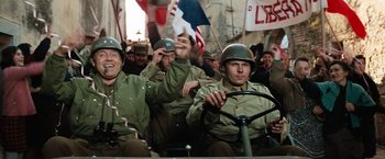 Movie still from “Kelly's Heroes” (1970), directed by Brian G. Hutton – A group of men in military uniforms riding in a vehicle; Medium shot, Low angle
